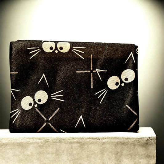 Black scarf with white cat face design on a light surface