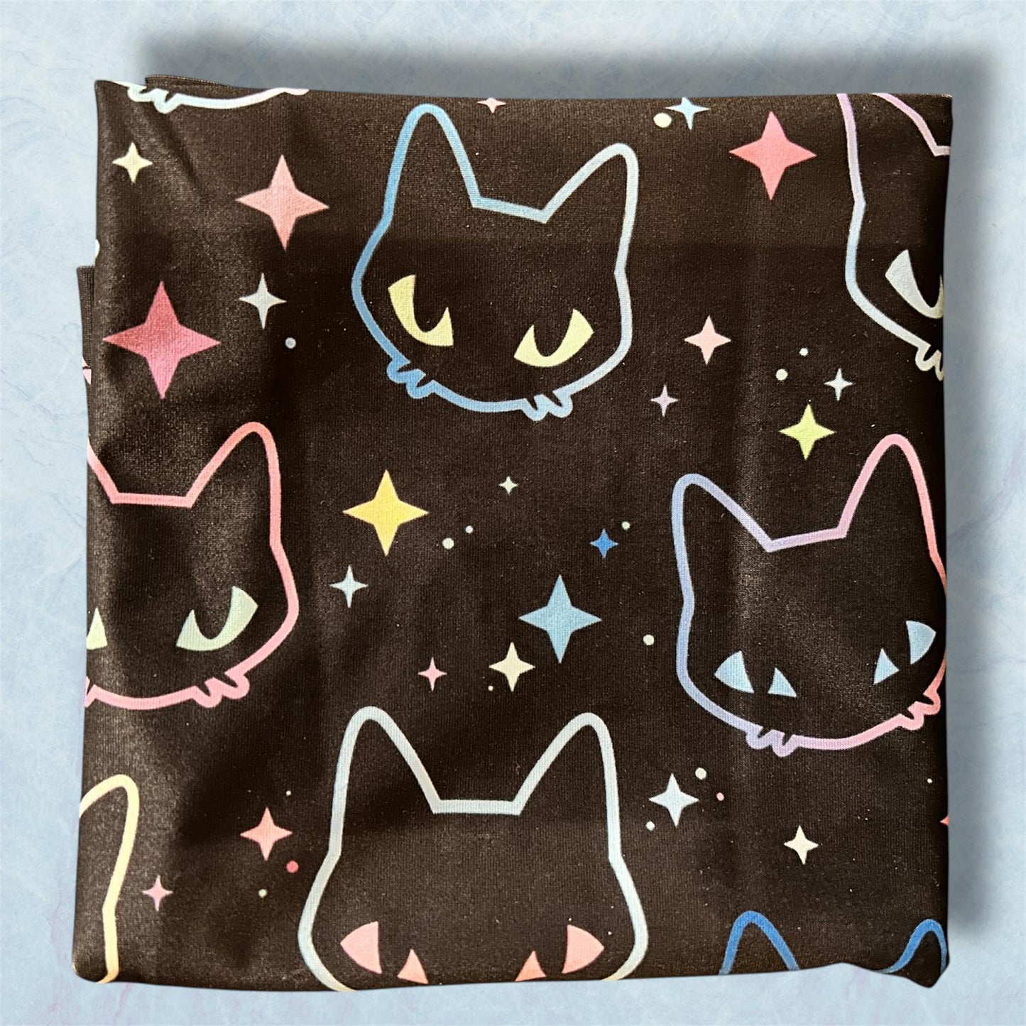 Folded fabric with cat and star pattern on a light blue background