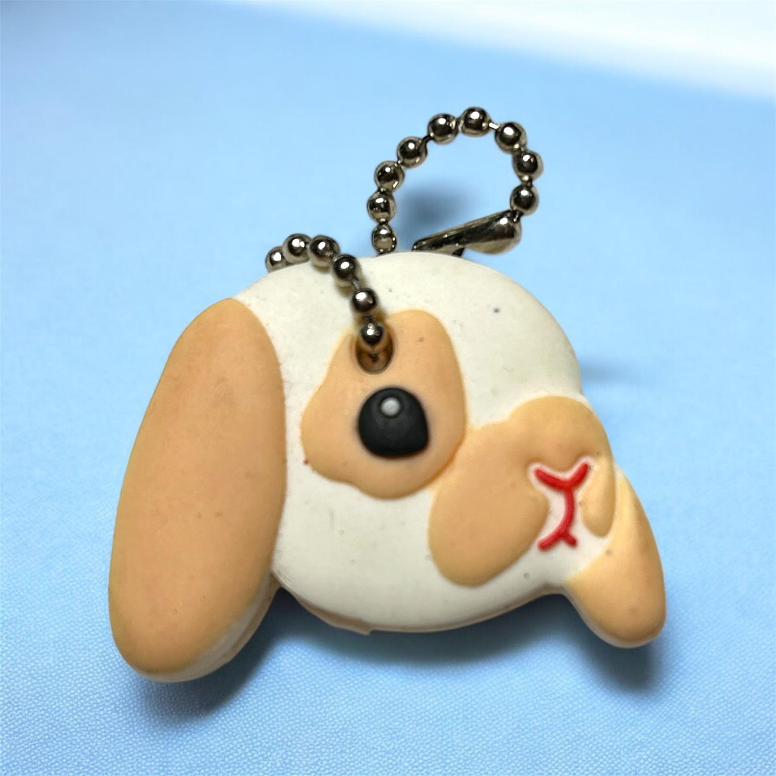 bunny shaped keychain with a red collar on a blue background